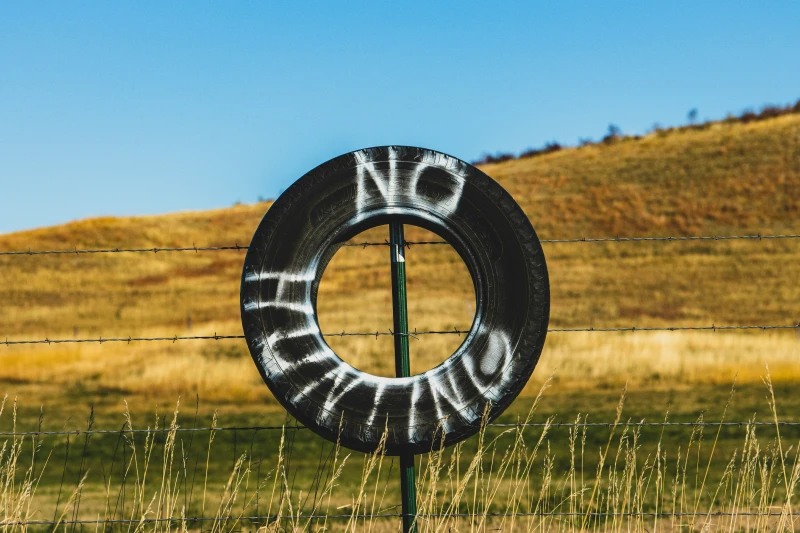 No Hunting written on a tire hanging on a pole